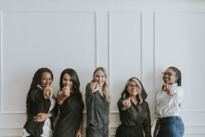Happy businesswomen pointing at the camera